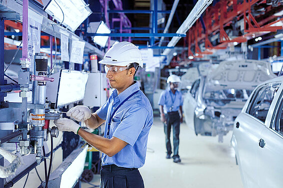 A Leadec employee maintaining the conveyor technology in an automotive factory. 