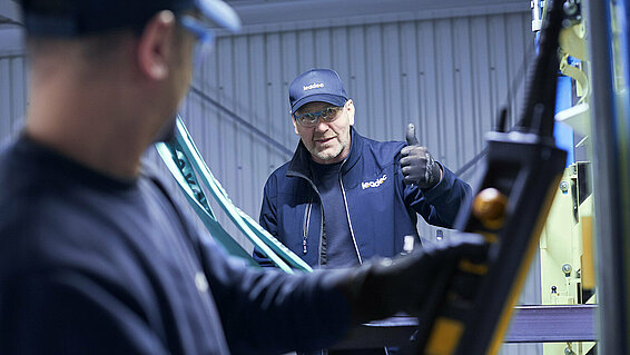 Two Leadec employees troubleshooting the conveyor system in an automotive factory.
