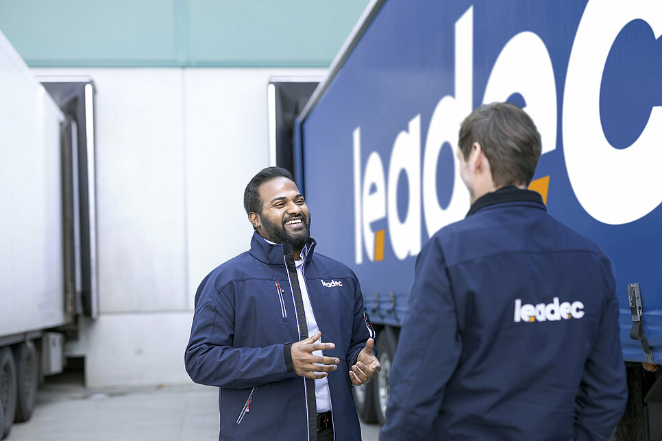 Two Leadec employees talking next to a truck