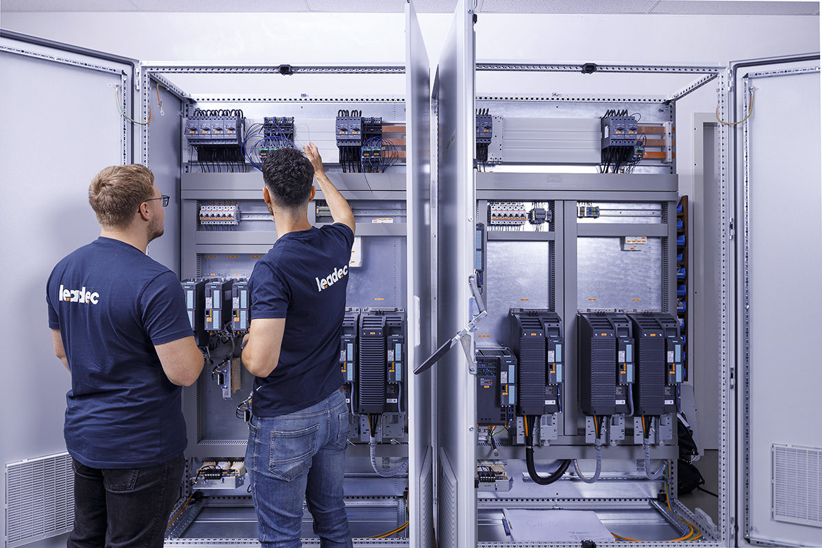 Two Leadec employees checking a switch cabinet.